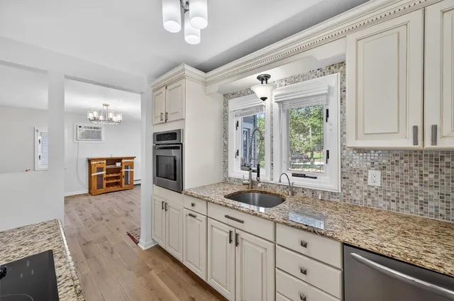 a kitchen with stainless steel appliances granite countertop a sink and a refrigerator