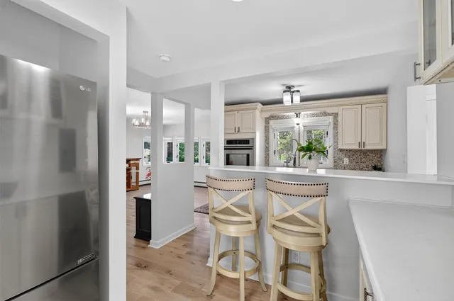 a kitchen with stainless steel appliances a dining table chairs and chandelier