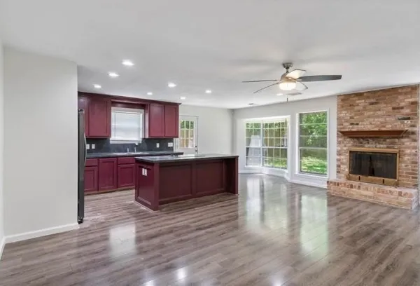 a kitchen with stainless steel appliances granite countertop a stove a refrigerator a sink a microwave oven with wooden floor and cabinets