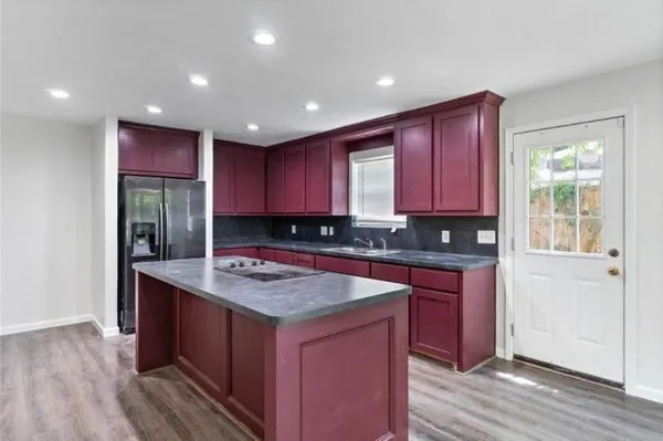 a kitchen with kitchen island granite countertop wooden cabinets a sink and dishwasher