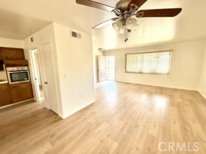 28811 Carmel Road Menifee, CA 92586 - Photo 4 of 14 a view of a kitchen with wooden floor a ceiling fan and windows