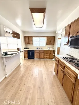 a large kitchen with kitchen island a large counter space a sink a window and stainless steel appliances