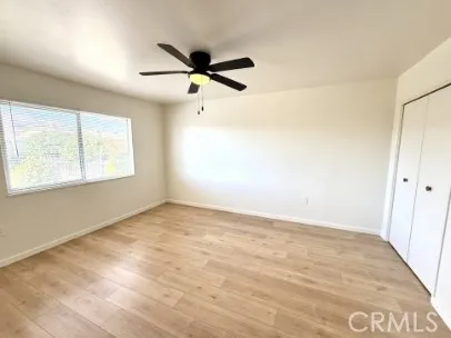 an empty room with a window and a fan