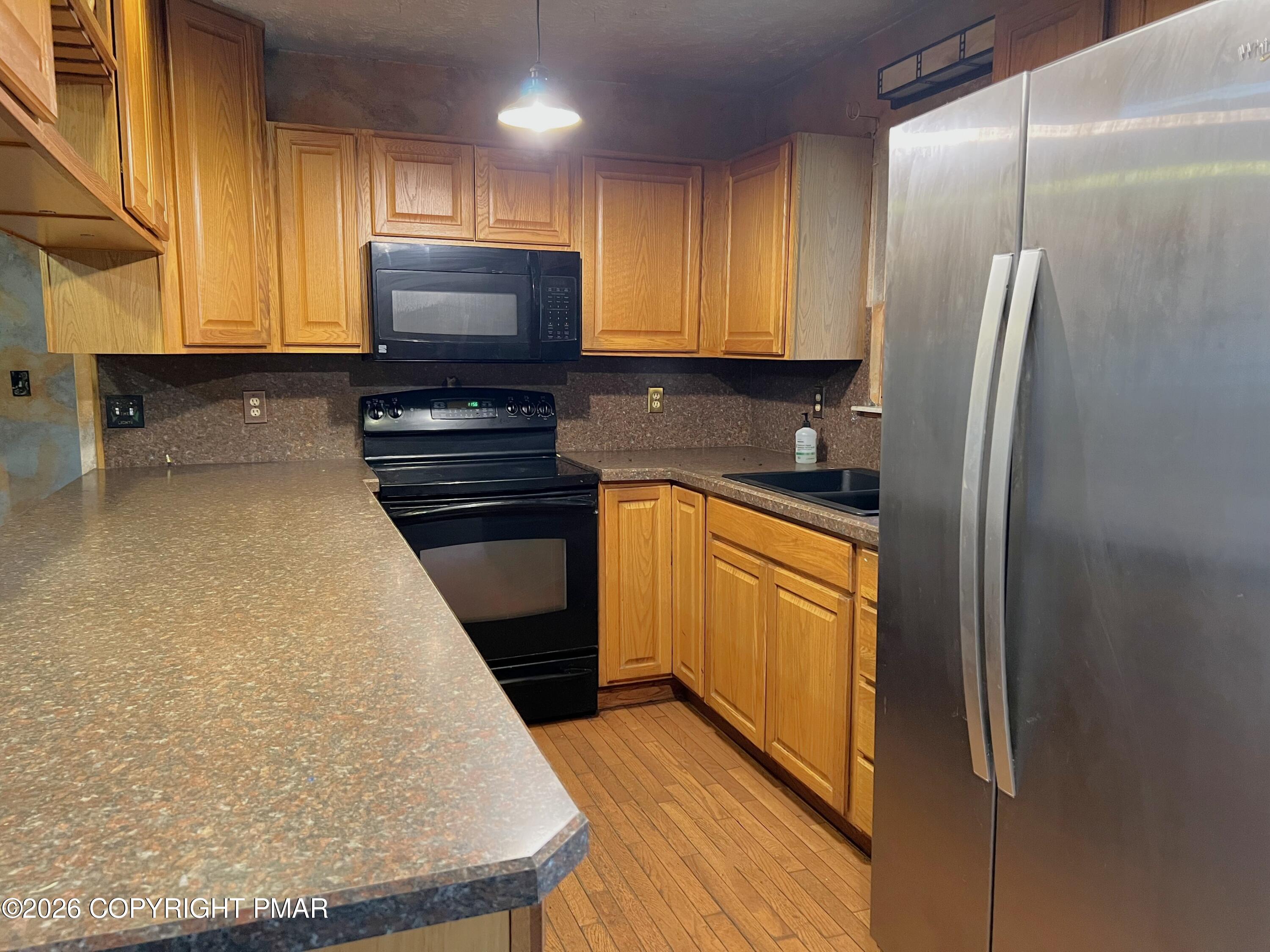152 Fairview Avenue Mount Pocono, PA 18344 - Photo 12 of 27 a kitchen with stainless steel appliances granite countertop a refrigerator a stove and a sink with wooden floor