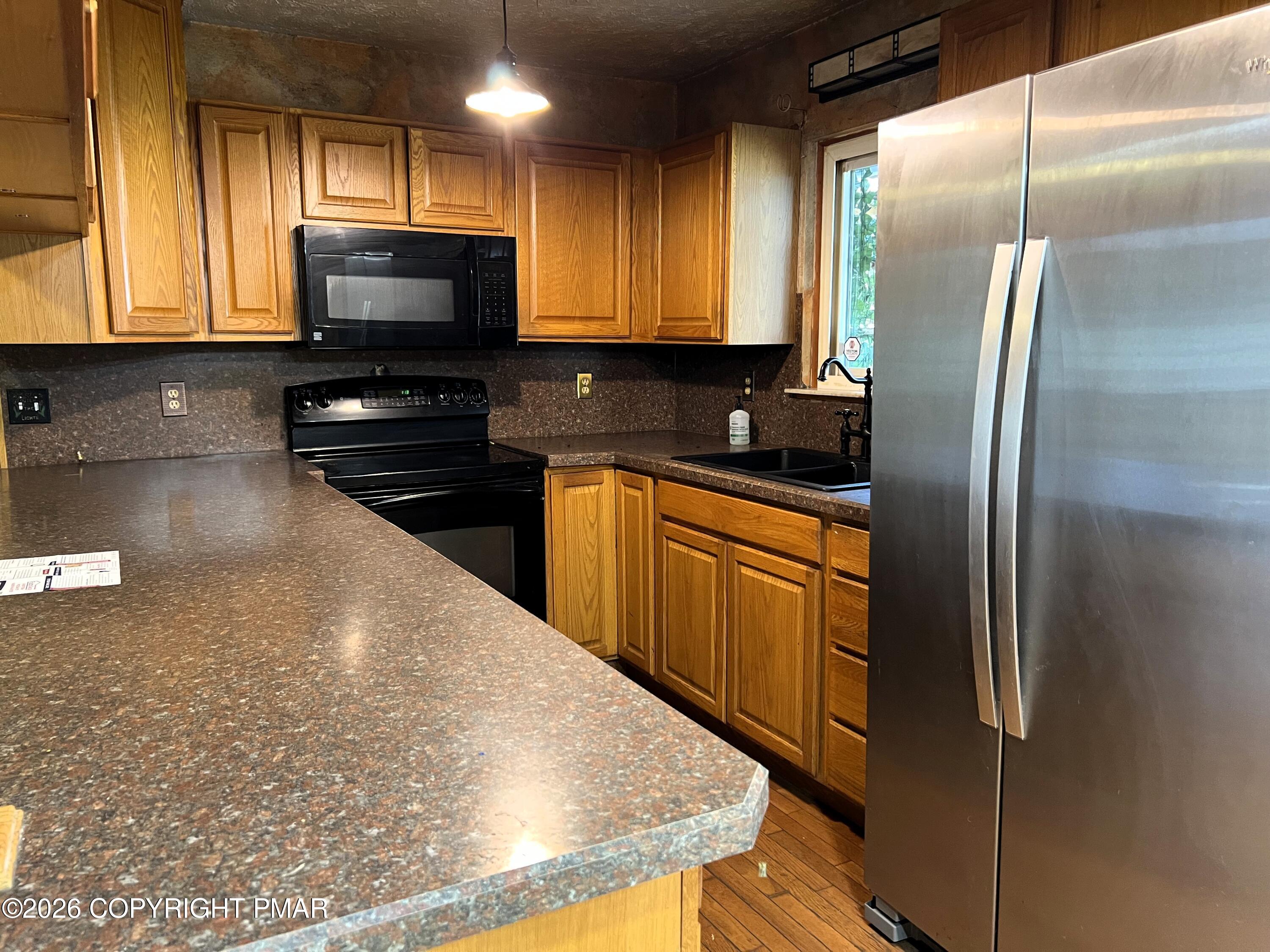 152 Fairview Avenue Mount Pocono, PA 18344 - Photo 14 of 27 a kitchen with stainless steel appliances granite countertop a refrigerator a stove top oven and a sink with wooden floor
