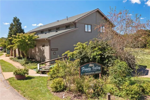 a backyard of a house with large trees and plants