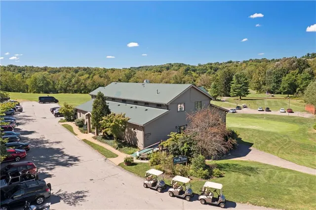 a view of a white house with a large windows and a yard