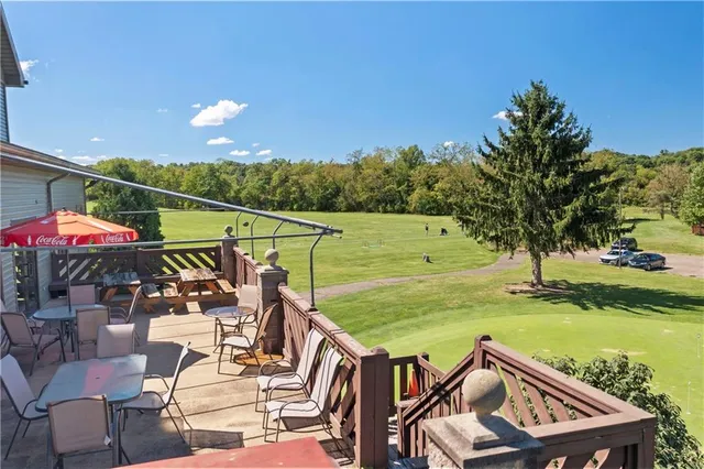 a view of a white house with large windows next to a road