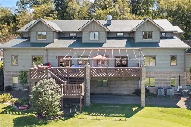 a view of a brick house with large windows and a chandelier