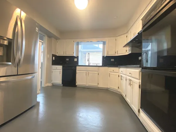 a kitchen with granite countertop white cabinets and stainless steel appliances