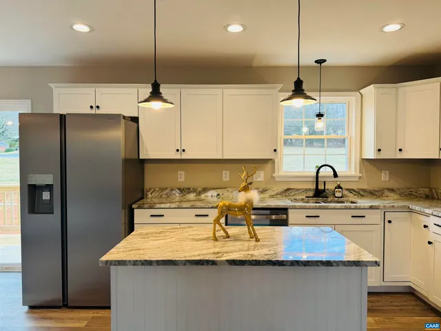 an empty room with chandelier fan and windows