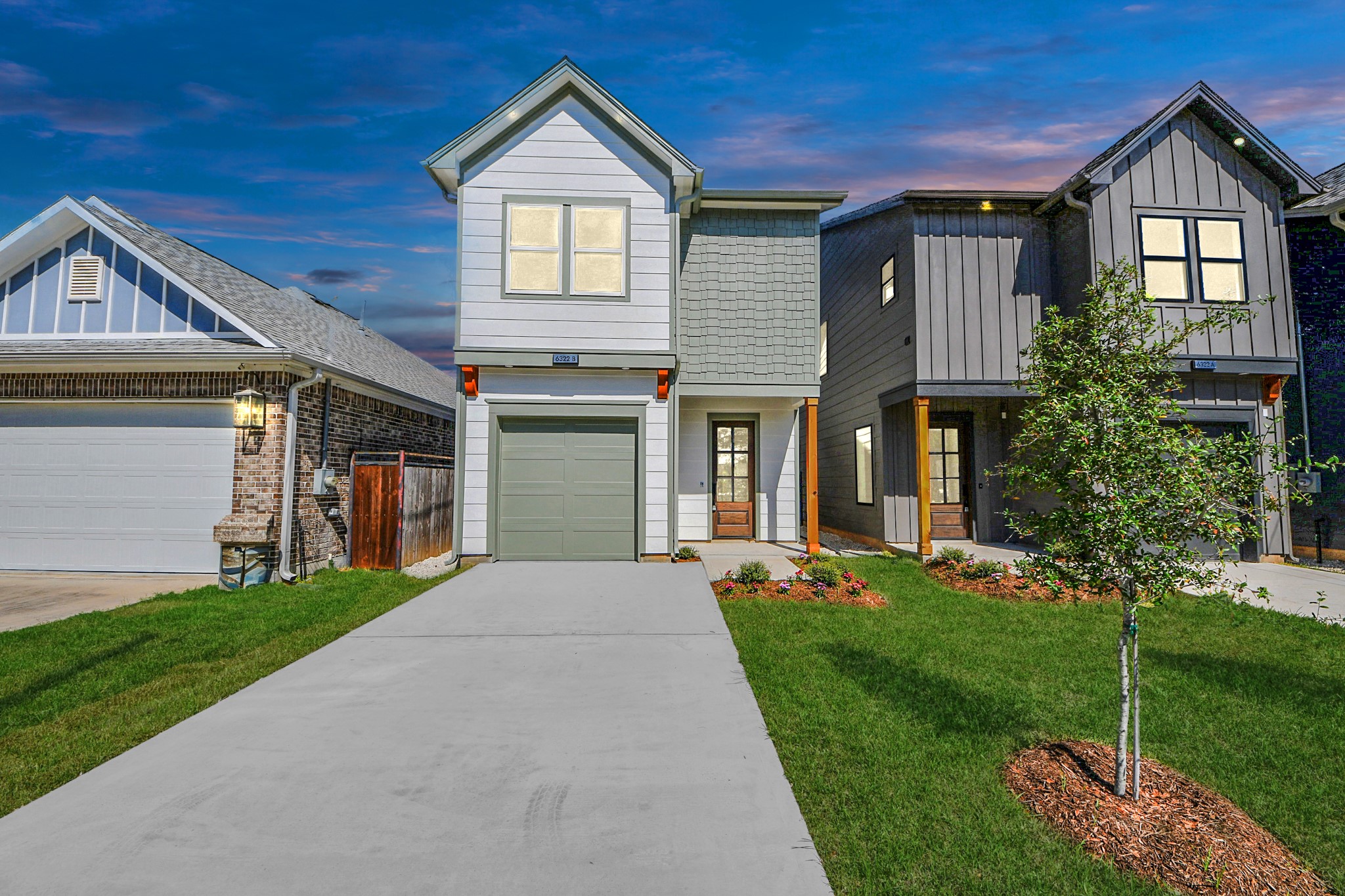 a front view of a house with a yard and trees