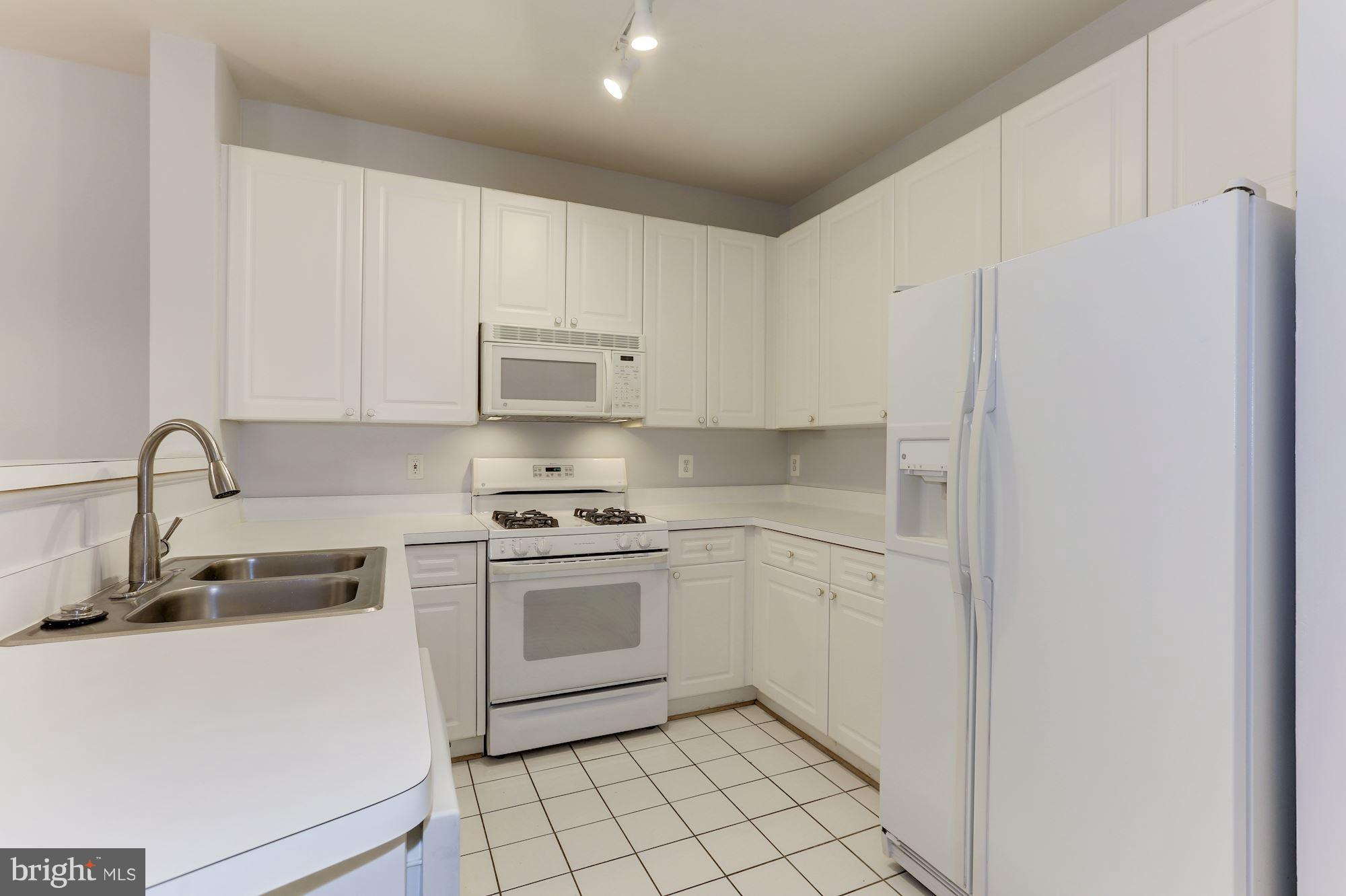 4330 Cannon Ridge Court, Unit 21 Fairfax, VA 22033 - Photo 4 of 24 a kitchen with white cabinets and white appliances