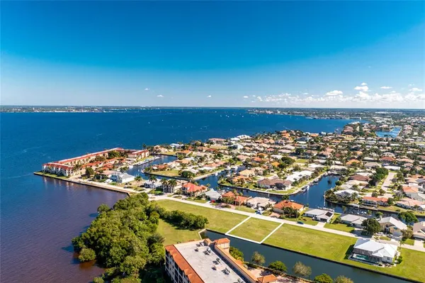 an aerial view of ocean and residential houses with outdoor space