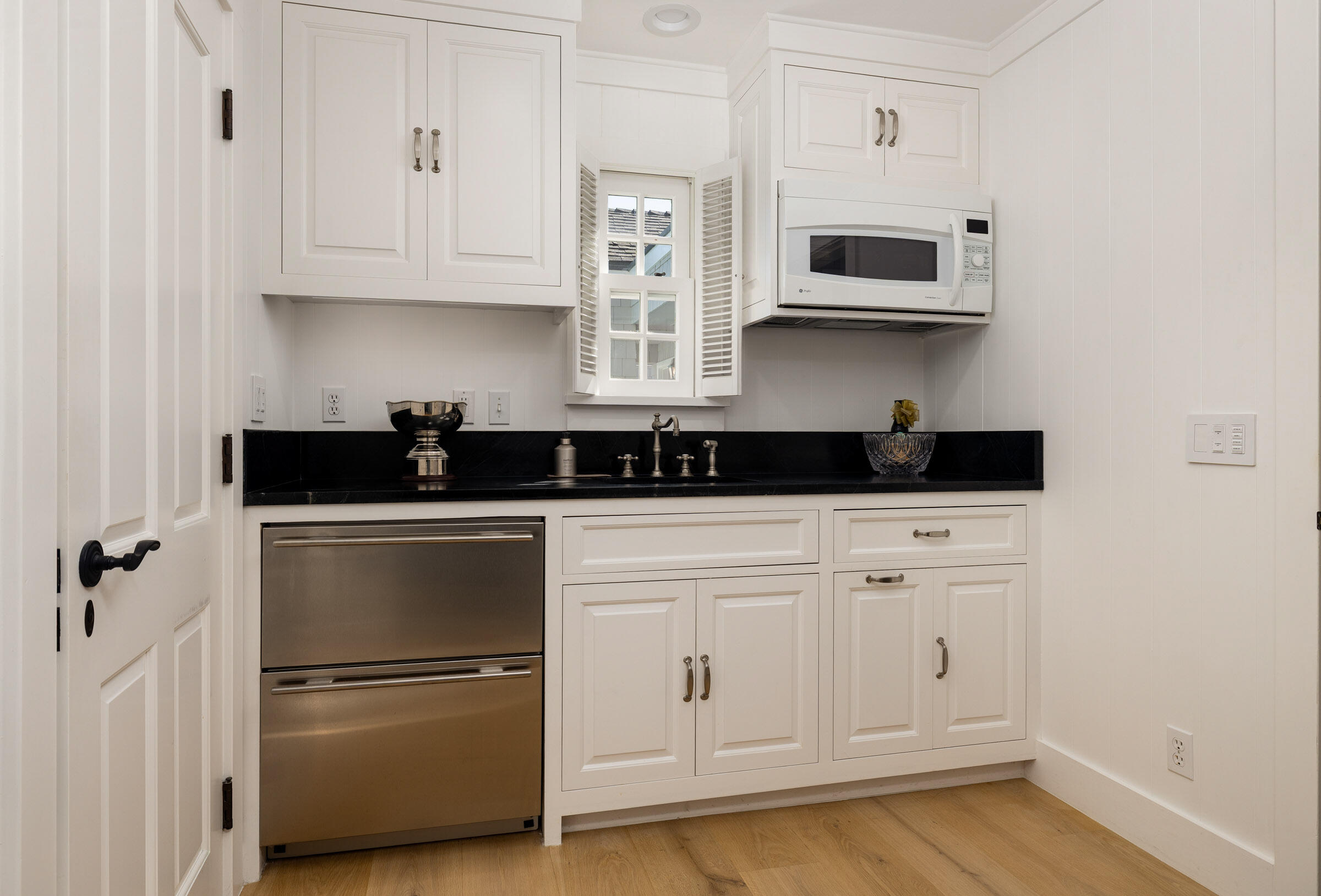 571 Sand Point Road Carpinteria, CA 93013 - Photo 45 of 49 a kitchen with white cabinets and black appliances