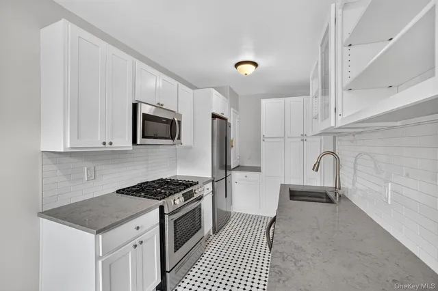 a kitchen with granite countertop a sink stove and microwave