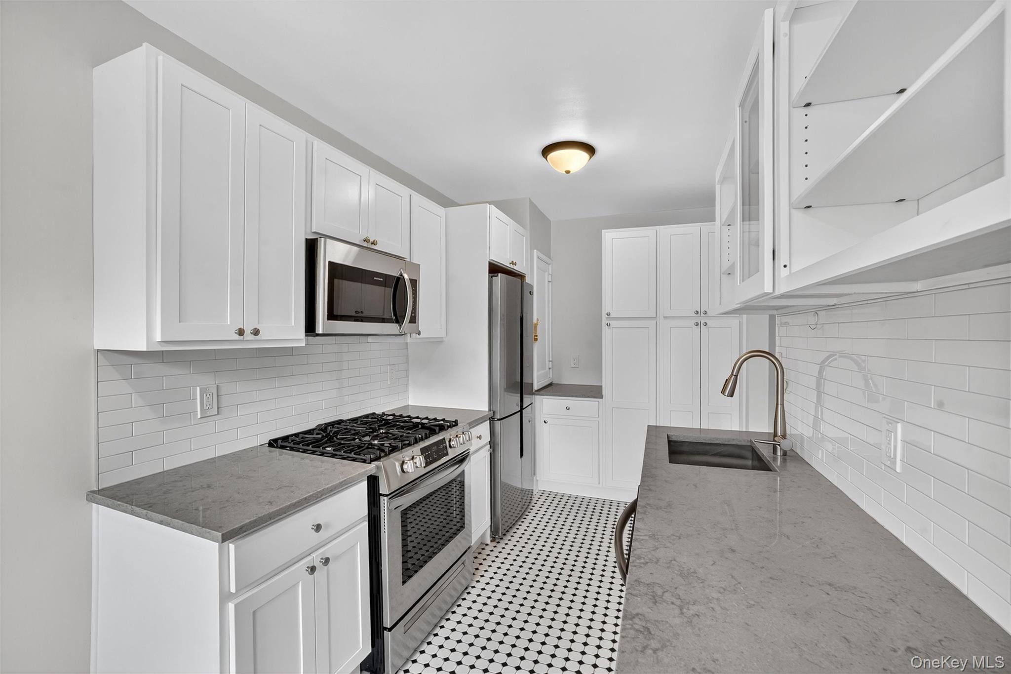 294 Bronxville Road, Unit 4C Bronxville, NY 10708 - Photo 11 of 26 a kitchen with granite countertop a sink stove and microwave