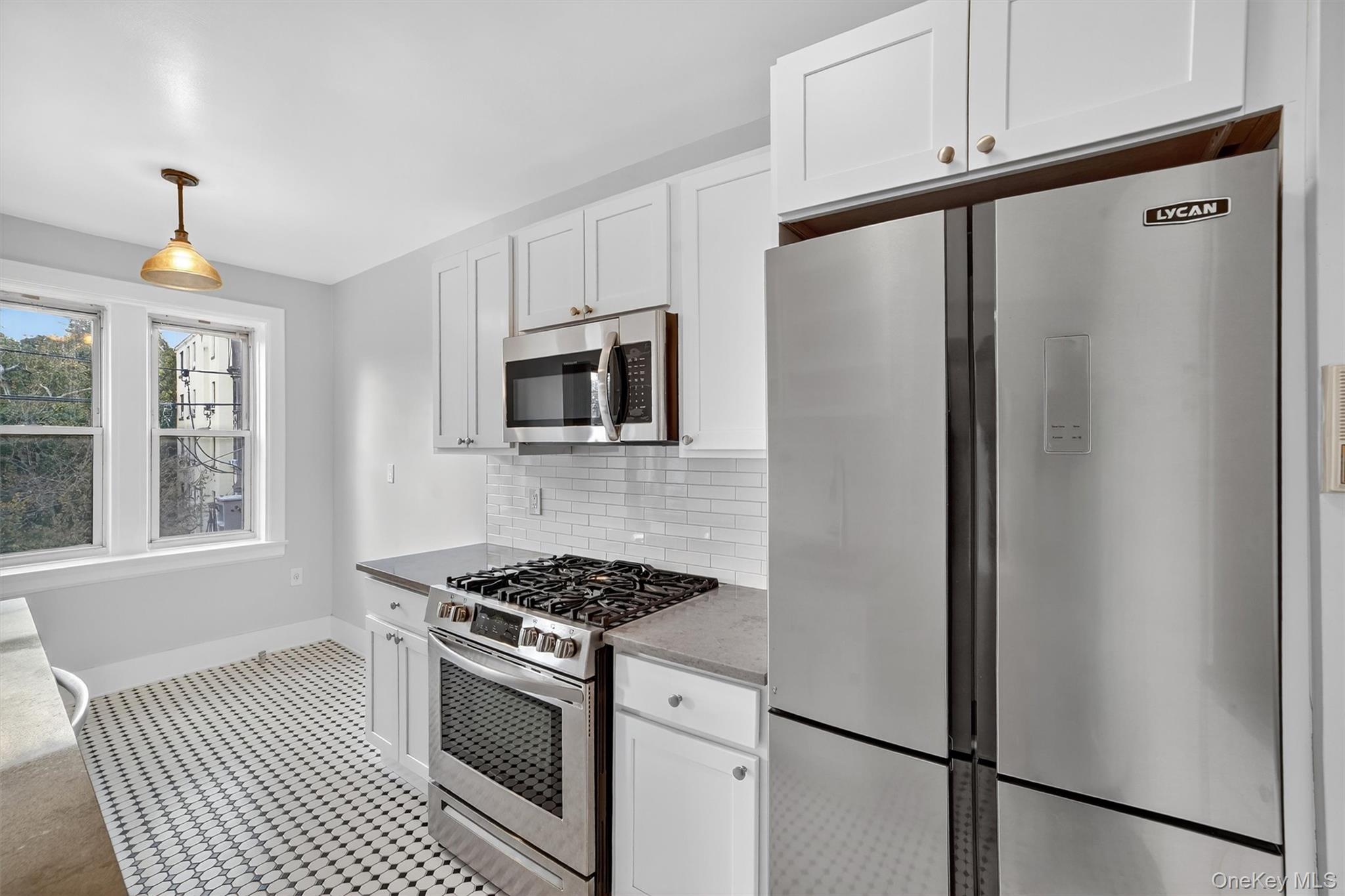 294 Bronxville Road, Unit 4C Bronxville, NY 10708 - Photo 14 of 26 a kitchen with stainless steel appliances granite countertop a refrigerator a sink a stove and white cabinets