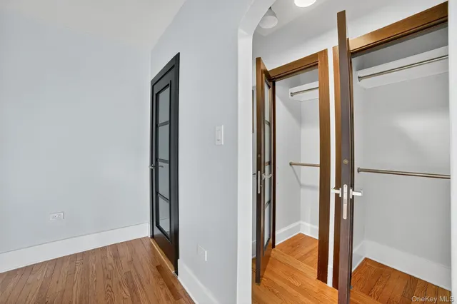 a view of a hallway with wooden floor and cabinet
