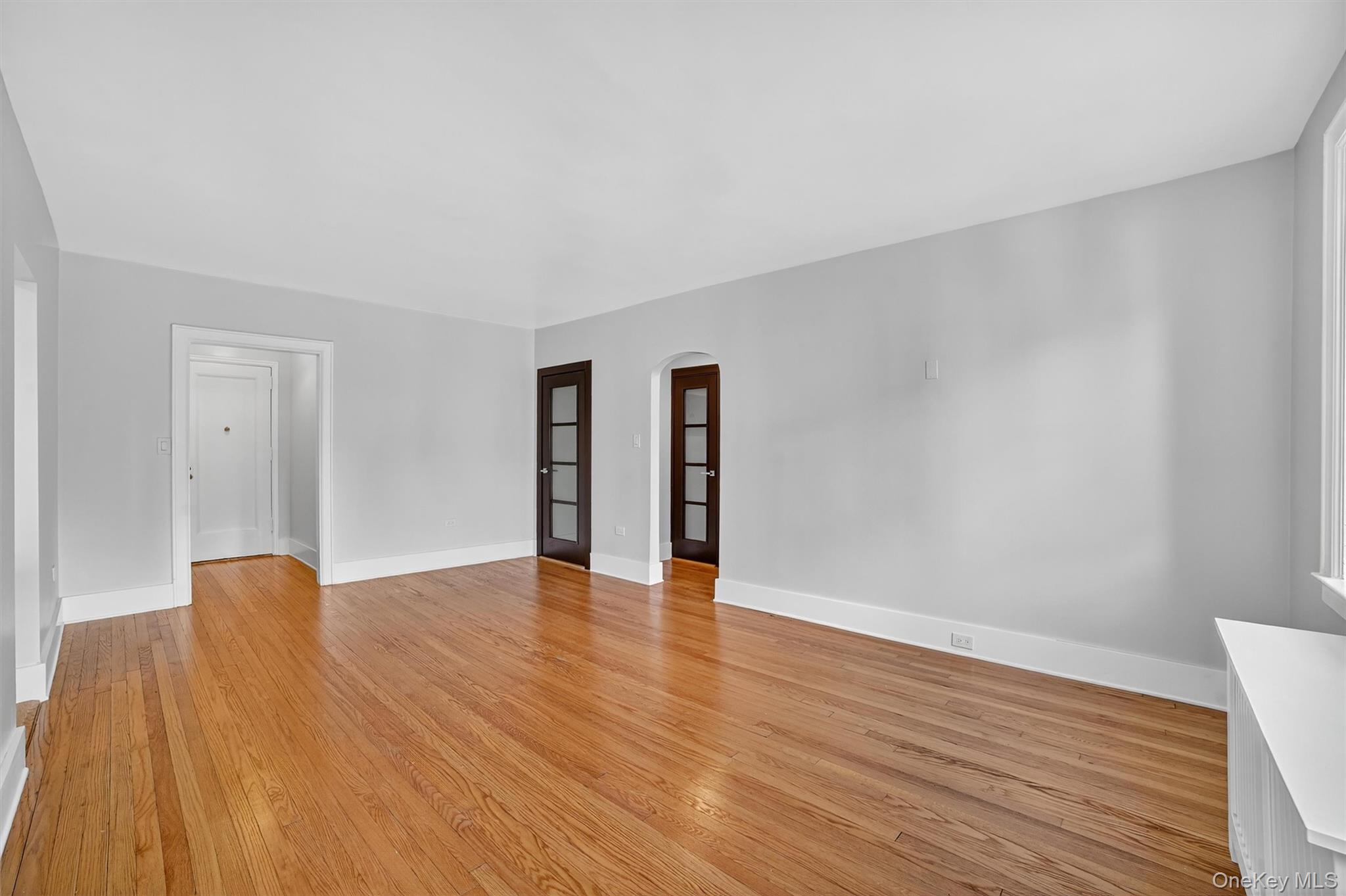 294 Bronxville Road, Unit 4C Bronxville, NY 10708 - Photo 8 of 26 a view of an empty room with wooden floor and a window