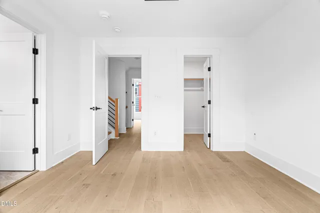 an empty room with wooden floor and a bathroom
