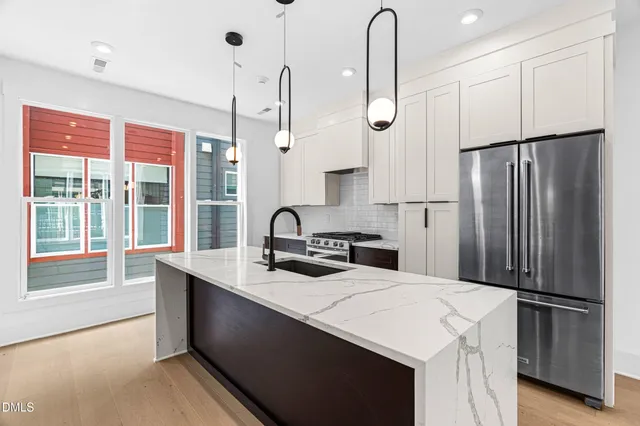 a kitchen with stainless steel appliances a refrigerator sink and cabinets