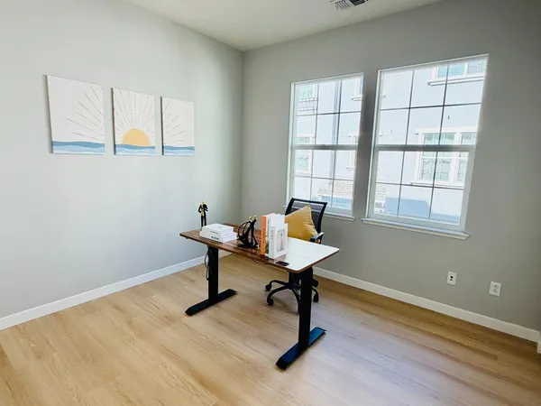 a view of a workspace with furniture and a window