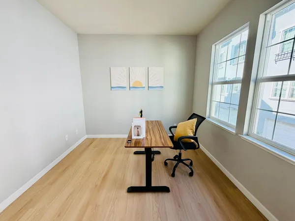 a view of a workspace with furniture and a window
