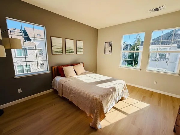 a bedroom with a bed and wooden floor