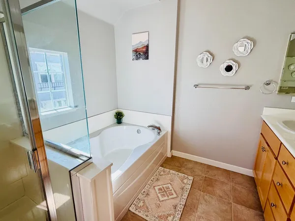 a bath tub sitting next to a white sink and a shower
