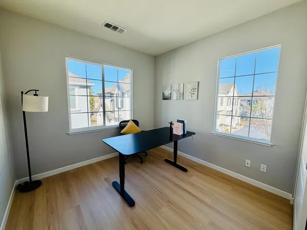 a workspace with wooden floor and a window