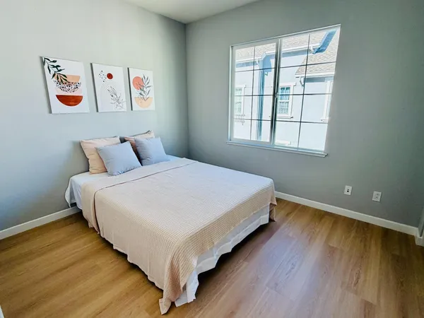 a bedroom with a bed and wooden floor