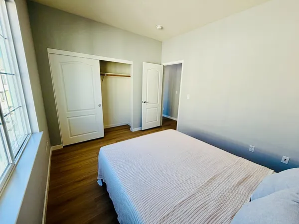 a bedroom with a bed and wooden floor