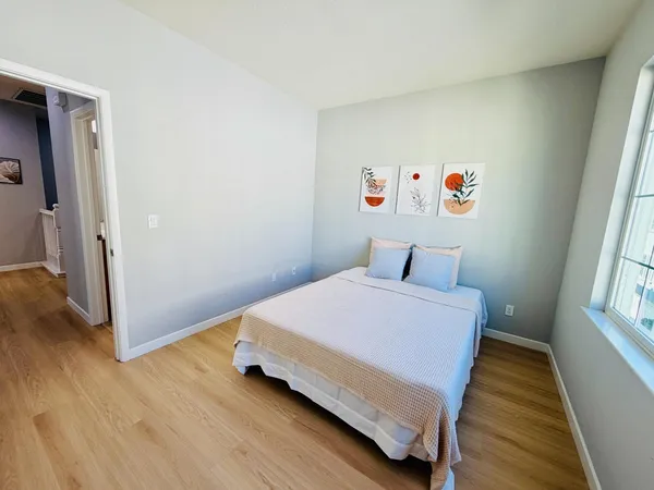 a bedroom with a bed and wooden floor