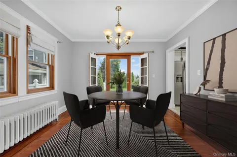a dining room with furniture a chandelier and wooden floor