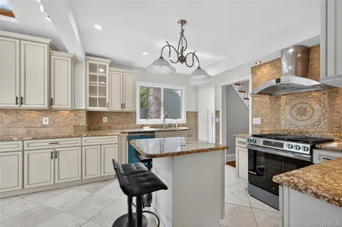 a kitchen with stainless steel appliances kitchen island granite countertop a sink and cabinets