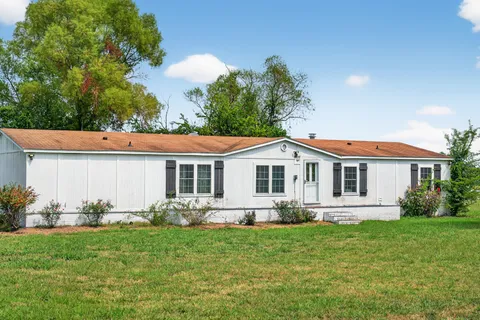 a kitchen with stainless steel appliances granite countertop a refrigerator a sink dishwasher a stove with wooden cabinets and floor