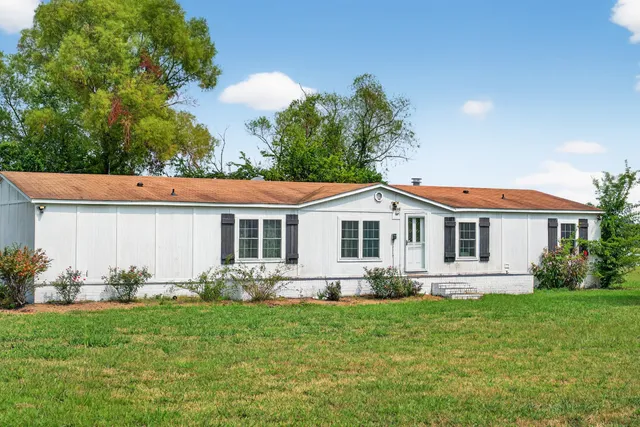 a kitchen with stainless steel appliances granite countertop a refrigerator a sink dishwasher a stove with wooden cabinets and floor