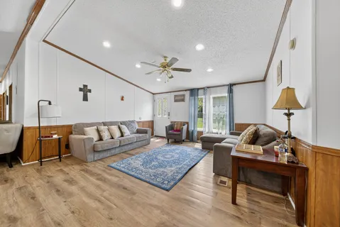 a living room with furniture a fireplace and wooden floor