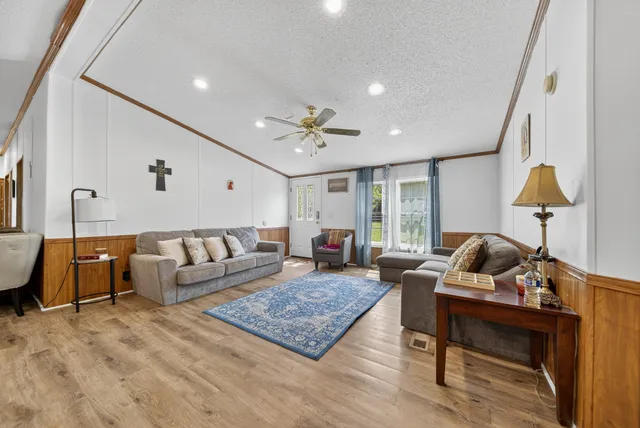 a living room with furniture a fireplace and wooden floor