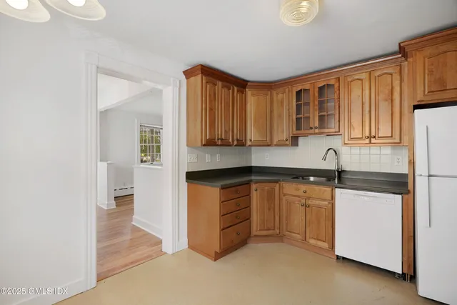 a kitchen with stainless steel appliances granite countertop a refrigerator a stove and a sink with cabinets