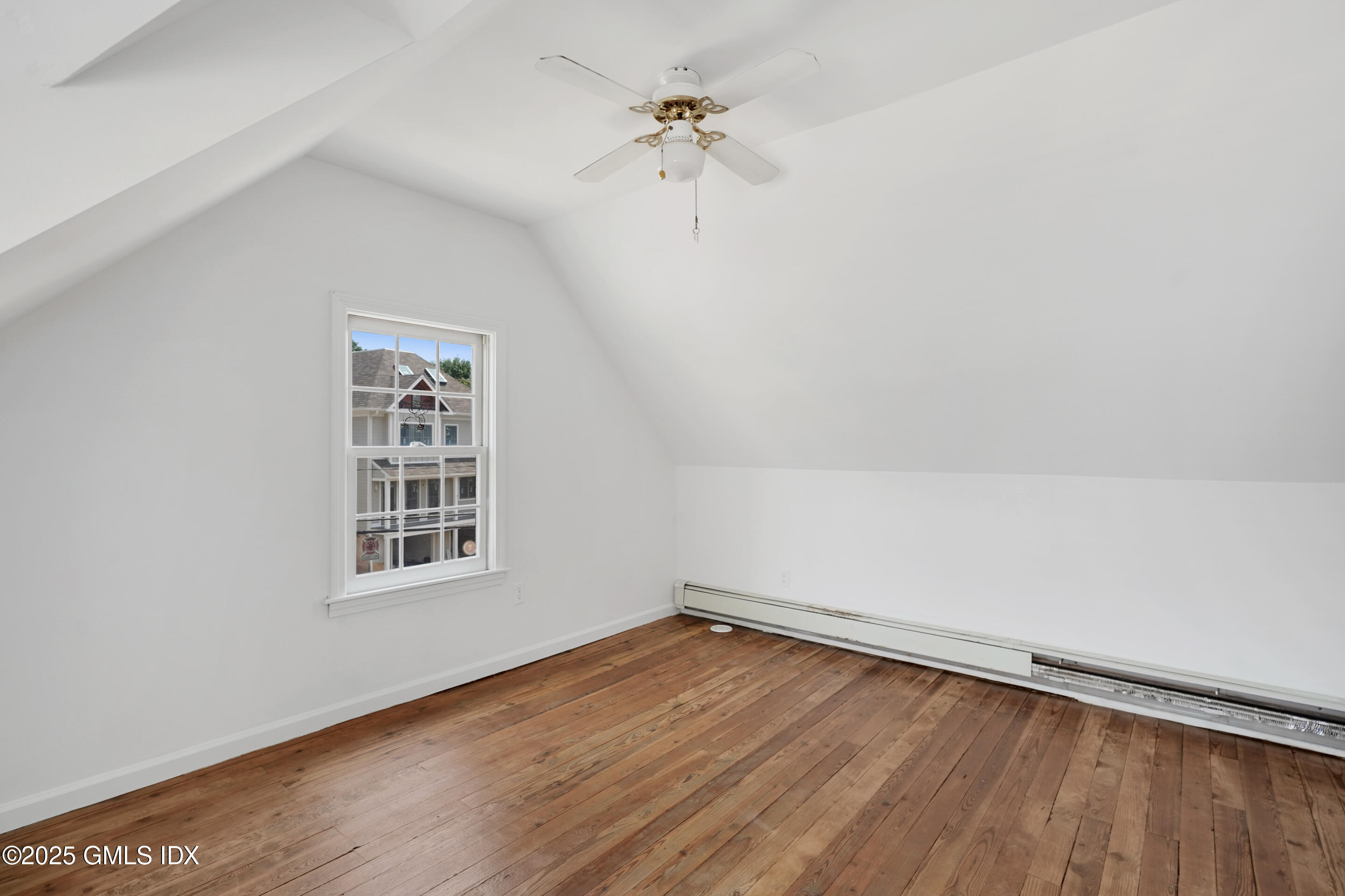 52 Locust Street Greenwich, CT 06830 - Photo 21 of 35 an empty room with wooden floor chandelier fan and windows