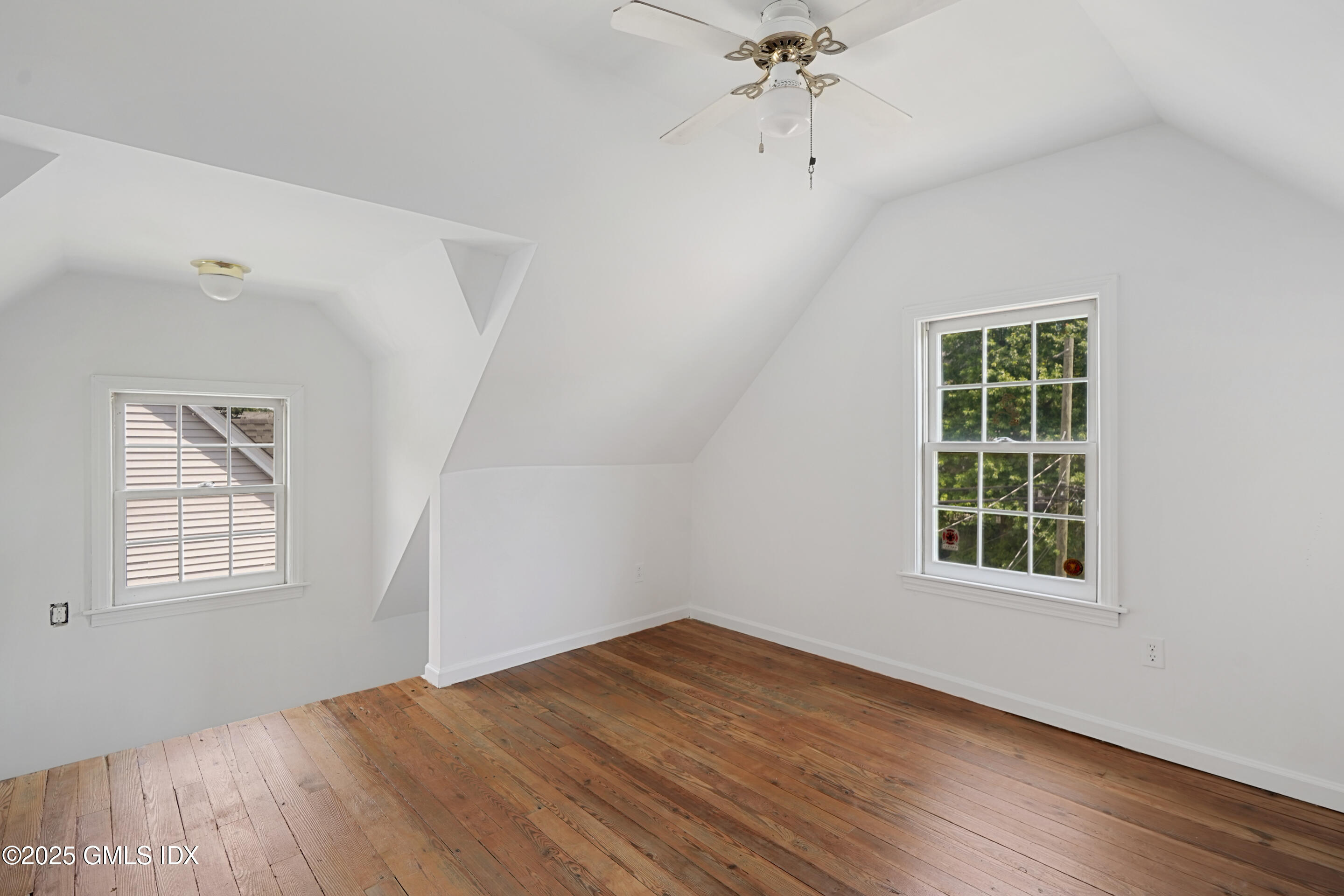 52 Locust Street Greenwich, CT 06830 - Photo 22 of 35 an empty room with wooden floor chandelier fan and windows