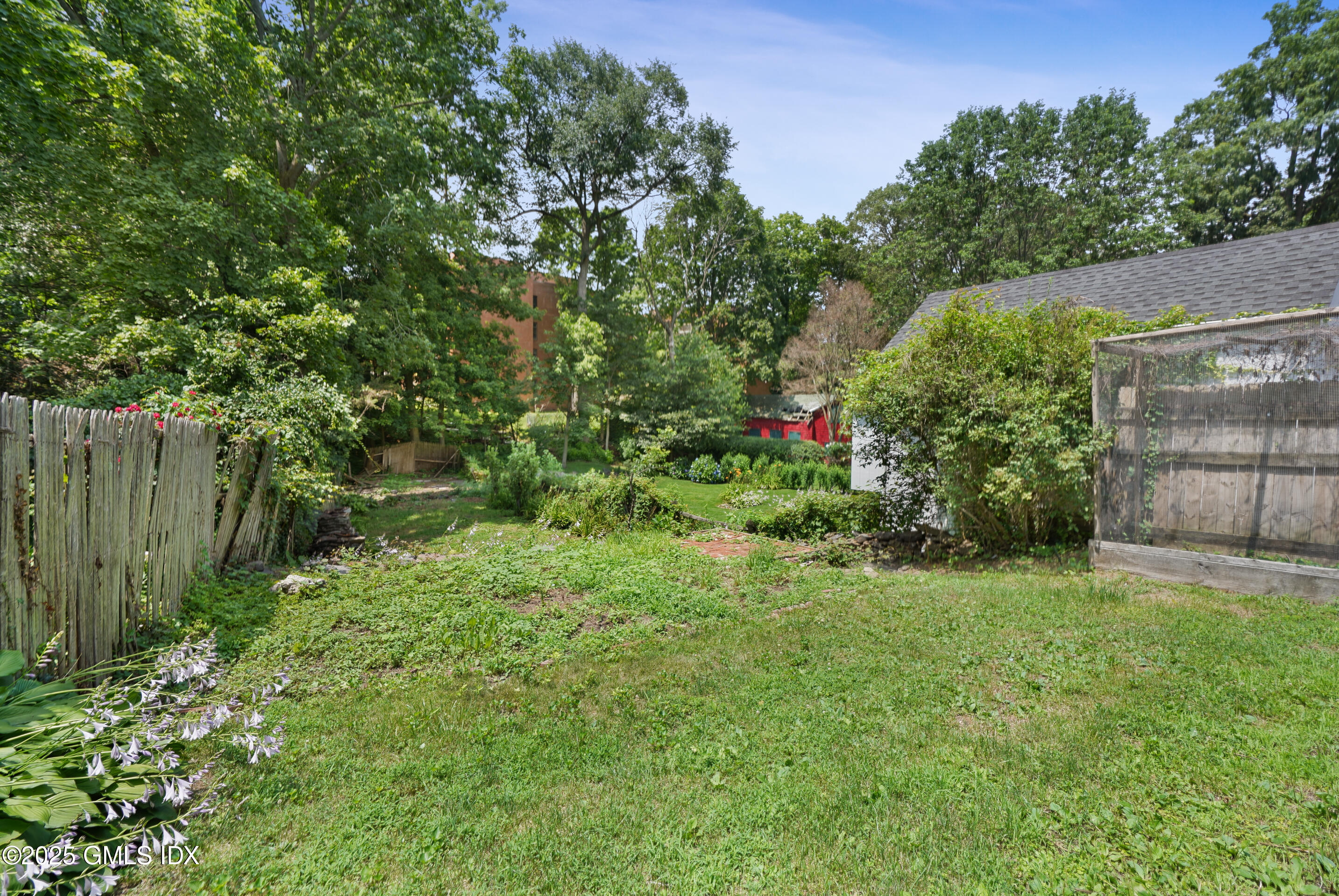 52 Locust Street Greenwich, CT 06830 - Photo 31 of 35 a view of a backyard with potted plants and large trees