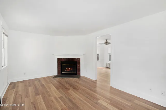 an empty room with wooden floor and a fireplace