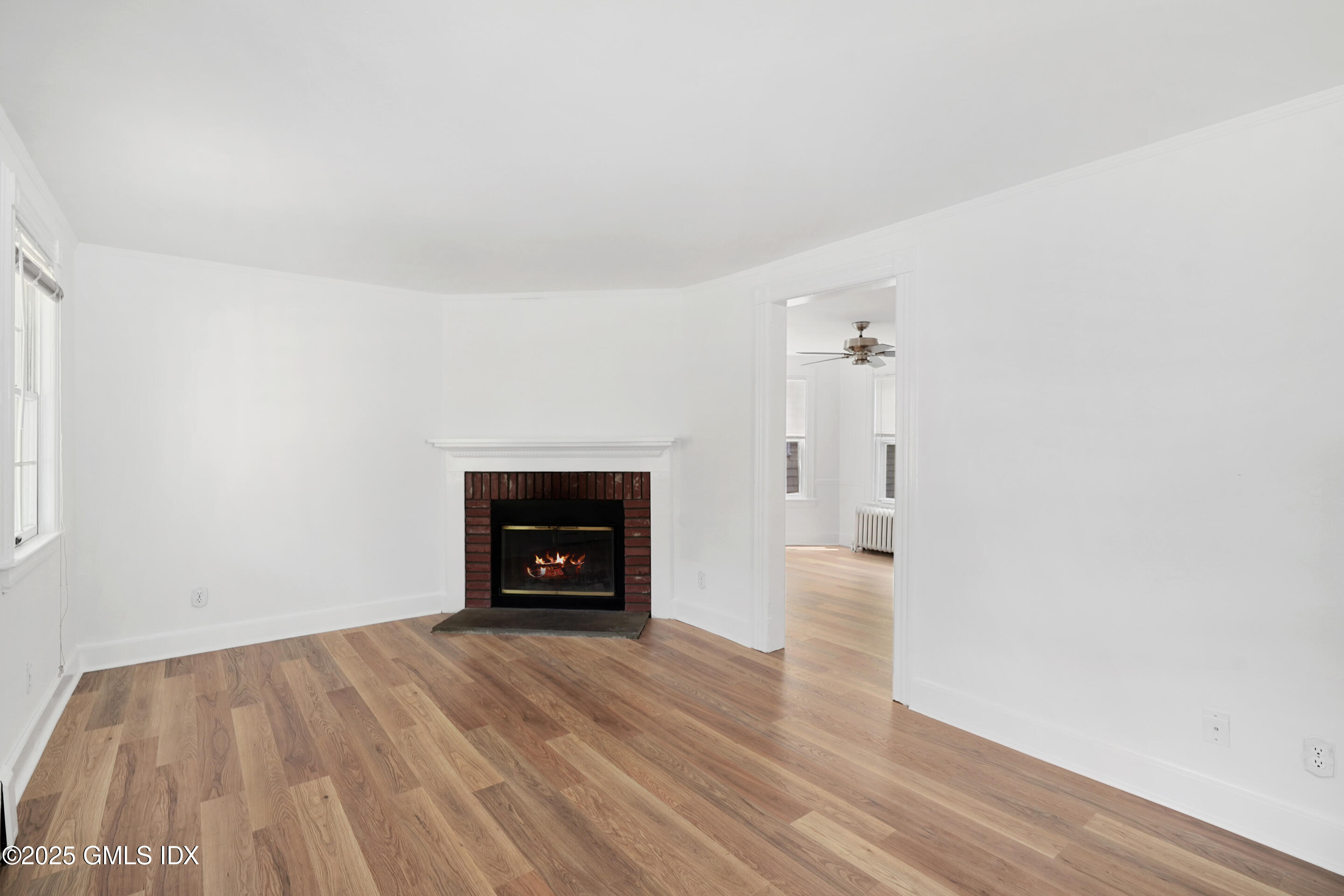 52 Locust Street Greenwich, CT 06830 - Photo 5 of 35 an empty room with wooden floor and a fireplace