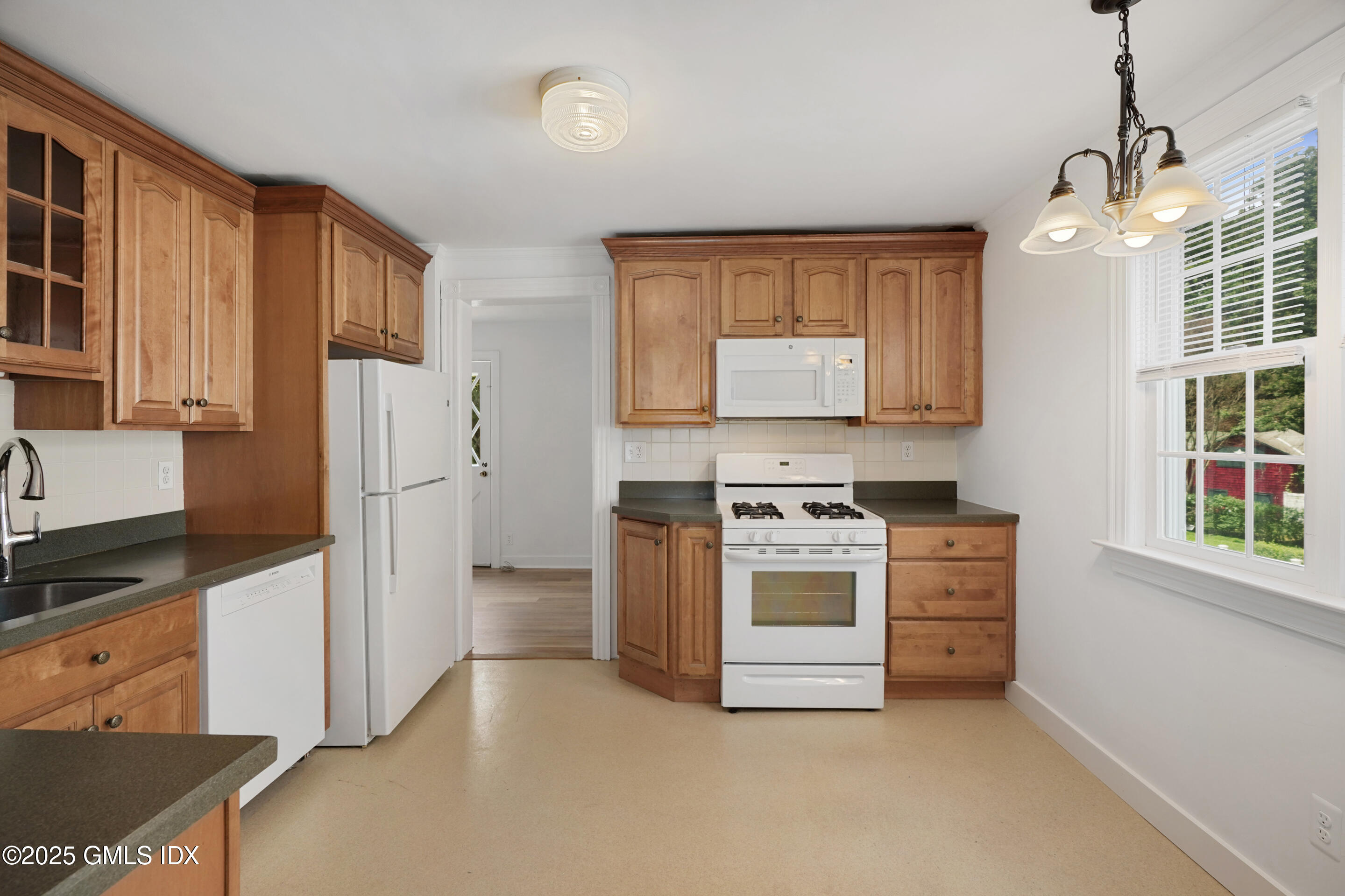 52 Locust Street Greenwich, CT 06830 - Photo 10 of 35 a kitchen with stainless steel appliances granite countertop a refrigerator a stove a sink dishwasher and white cabinets with wooden floor