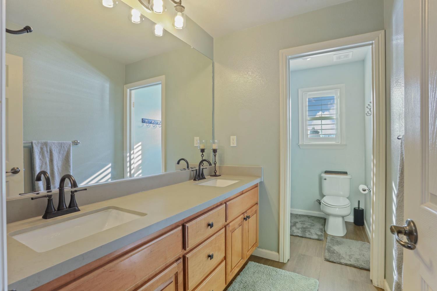 565 Bodeson Court Ripon, CA 95366 - Photo 45 of 65 a bathroom with a sink a toilet and a mirror