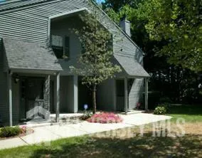 a view of a house with yard and tree
