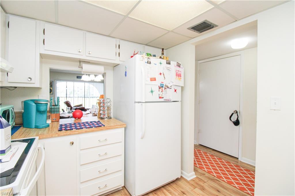 41 High Point Circle South, Unit 303 Naples, FL 34103 - Photo 12 of 39 a kitchen with a refrigerator and cabinets